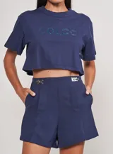 Remera corta azul con cuello redondo y logo Colcci bordado en el frente.