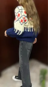Sweater de lana merino con cuello redondo y diseño con motivos geométricos en tonos azul, marrón, naranja, verde y beige.