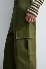 Pantalón cargo verde oliva de corte relaxed fit, confeccionado en tejido de algodón compacto con estructura twill. Cuenta con bolsillos frontales, traseros de vivo y bolsillos plastrón con solapa en las perneras.