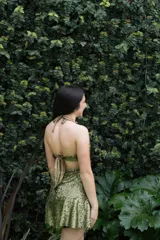 Vestido corto de fiesta color verde esmeralda brillante, con escote strapless, argolla metálica en el busto, breteles finos y cut-outs en el delantero.
