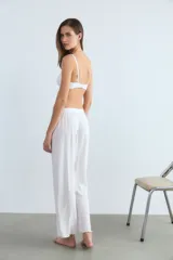 Pantalón blanco de poliéster y algodón con textura acanalada.