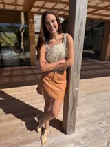 Top corto color nude dorado con textura de rafia y apliques artesanales de cuero a tono.