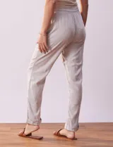 Pantalón de lino color gris claro, marca Cable & Gauge. Tiene pretina ancha elastizada con lazo de ajuste, bolsillos delanteros y ruedo con botamanga.