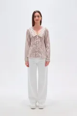 Camisa de algodón con estampado de rayas verticales en tonos beige y marrón. Presenta un cuello solapa con detalle de volados, cierre frontal con botones y mangas largas.