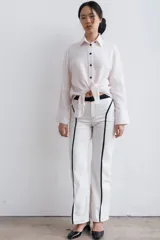 Pantalón de denim blanco con aplique de línea vertical negra en el frente.