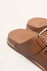 Sandalias marrones de cuero vacuno con doble tira y hebillas metálicas ajustables.