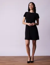 Vestido corto negro de seda fría, marca Tash & Sophie. Tiene cuello redondo y mangas con volados.