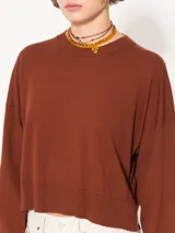 Sweater tejido suave y flojo, color crudo, con cuello redondo y mangas largas.