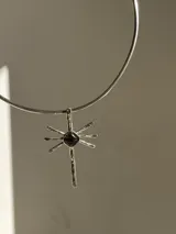 Gargantilla con cordones de gamuza marrón y dije de sol dorado con piedra de ágata en el centro.