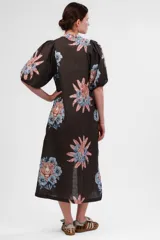 Vestido camisero midi de algodón y lino color gris con estampado de tigresas y flores en tonos azules y naranjas. Tiene cuello mao, mangas abullonadas cortas y cierre frontal con botones.