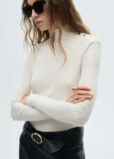 Camiseta de punto de canalé color crudo, de corte slim fit, cuello perkins y manga larga. Presenta cierre de botones metálicos en el hombro.