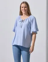 Blusa celeste con rayas verticales blancas, escote redondo con cordón ajustable y mangas cortas con volados.
