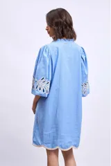 Vestido blanco de lino con escote en V, mangas cortas abullonadas y bordados florales en beige en mangas y ruedo.