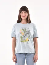 Remera celeste con estampado de hojas y flores tropicales.