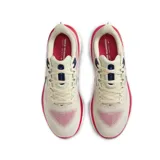 Championes de running Nike Vomero 17, color crema con detalles en azul marino y rojo.