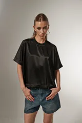 Blusa negra de poliéster con cuello redondo y corte ancho.