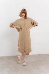 Vestido camisero midi color verde militar, de lino 100%, con silueta oversize, cuello camisero, mangas 3/4 con botón para ajustar y aberturas laterales.