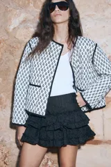 Minifalda negra con bordado floral y volantes escalonados.