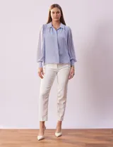 Camisa celeste de gasa, marca Tahari. Cuello con solapa y abertura central con botones ocultos. Manga larga abullonada con puño y botones. Forro de gasa a tono.