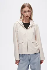 Campera color crudo de lino con capucha, cierre frontal y bolsillos plaqué.