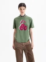 Remera verde de algodón pima, de mangas cortas, cuello redondo y fit amplio. Presenta una estampa frontal de tres cerezas en tonos rojos y blancos.