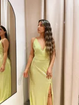 Vestido largo metalizado con escote en V, breteles finos y tajo profundo.