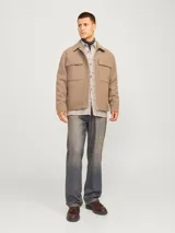 Sobrecamisa beige a cuadros con dos bolsillos frontales con botón, de manga larga y corte recto.