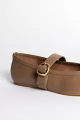 Ballerinas negras de cuero con tira sobre el empeine y hebilla dorada.