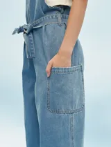 Mono largo de denim celeste con breteles regulables y lazo en la cintura.