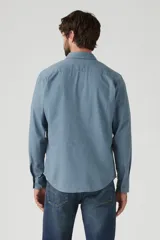 Camisa celeste de lino con un bolsillo en el pecho, de manga larga y corte clásico.