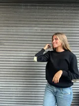 Sweater negro de lana merino con apliques rectangulares de cuero color plateado en los codos.