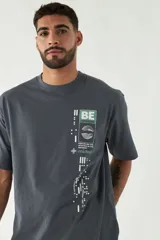 Remera color rosa viejo de corte amplio con estampa en el frente que incluye texto y diseño gráfico.