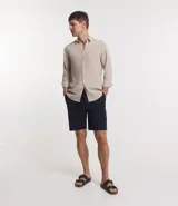 Bermuda de hombre color azul marino, confeccionada en sarga de algodón con elastano. Tiene cintura elástica con cordón ajustable y un bolsillo trasero.
