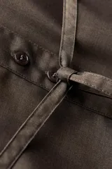 Camisa marrón de Zara Woman Collection confeccionada en hilatura con viscosa, de cuello solapa y manga larga acabada en puño. Presenta un bolsillo de plastrón en el pecho, cinturón en mismo tejido ajustable con lazadas y bajo asimétrico.