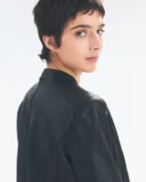 Campera negra de cuero con cierre frontal y detalles de costura.