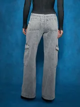 Jean cargo de tiro alto, color gris lavado, con corte ancho y pierna acampanada. Presenta bolsillos cargo grandes en los muslos y costuras marcadas.