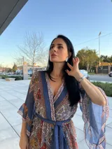 Vestido largo estampado con escote en V, mangas anchas y lazo en la cintura.