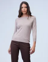 Buzo de punto fino color beige, con cuello a la base y mangas 3/4 de estilo raglán.