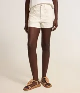 Short de cintura alta color crema, confeccionado en sarga con bordado floral, trabillas en la cintura, cierre tradicional y bolsillos.
