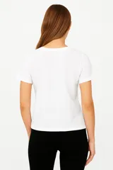 Remera blanca de manga corta con estampa de flor negra, texto y números.