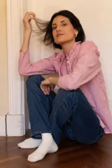 Camisa de rayas rojas y blancas de corte holgado, con detalles románticos y femeninos.