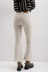 Pantalón jean marrón acampanado con detalle desflecado en el bajo y tiro medio.