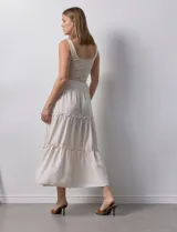 Falda midi a rayas verticales celestes y blancas, con pretina ancha elastizada en punto smock y volados en los cortes.