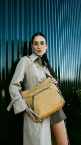 Cartera de simil cuero color rosa, con apertura superior con cierre, bolsillo frontal con cierre y tachas metálicas, bolsillos verticales y bolsillo trasero con cierre. Incluye división al medio y bolsillos internos.