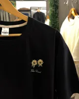 Remera negra de corte clásico, con estampado en la espalda con el texto "San Diego", flores y "California Tribe Brand".