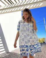 Vestido camisero corto de algodón con estampado de guardas geométricas en azul y blanco, con cuello en V y mangas cortas.