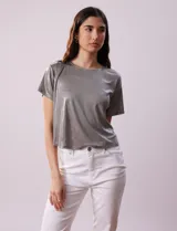 Blusa gris metalizada de tejido lurex, marca June & Hudson, con cuello redondo y ruedo con nudo en la espalda.