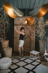 Chaleco negro de vestir, con escote en V y cierre frontal de botones dorados.