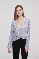 Blusa estampada con flores blancas y negras, escote en V con detalle de encaje y mangas largas.