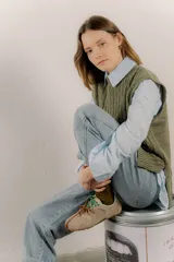 Zapatillas urbanas de cuero color tostado, con cordones verdes y suela de goma.